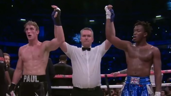 A boxing referee raises the hands of Logan Paul and KSI after the Youtubers' first fight ended in a draw.