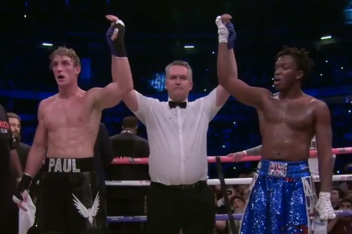 A boxing referee raises the hands of Logan Paul and KSI after the Youtubers' first fight ended in a draw.
