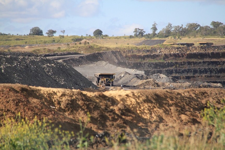 A dump truck drives through a coal mine.