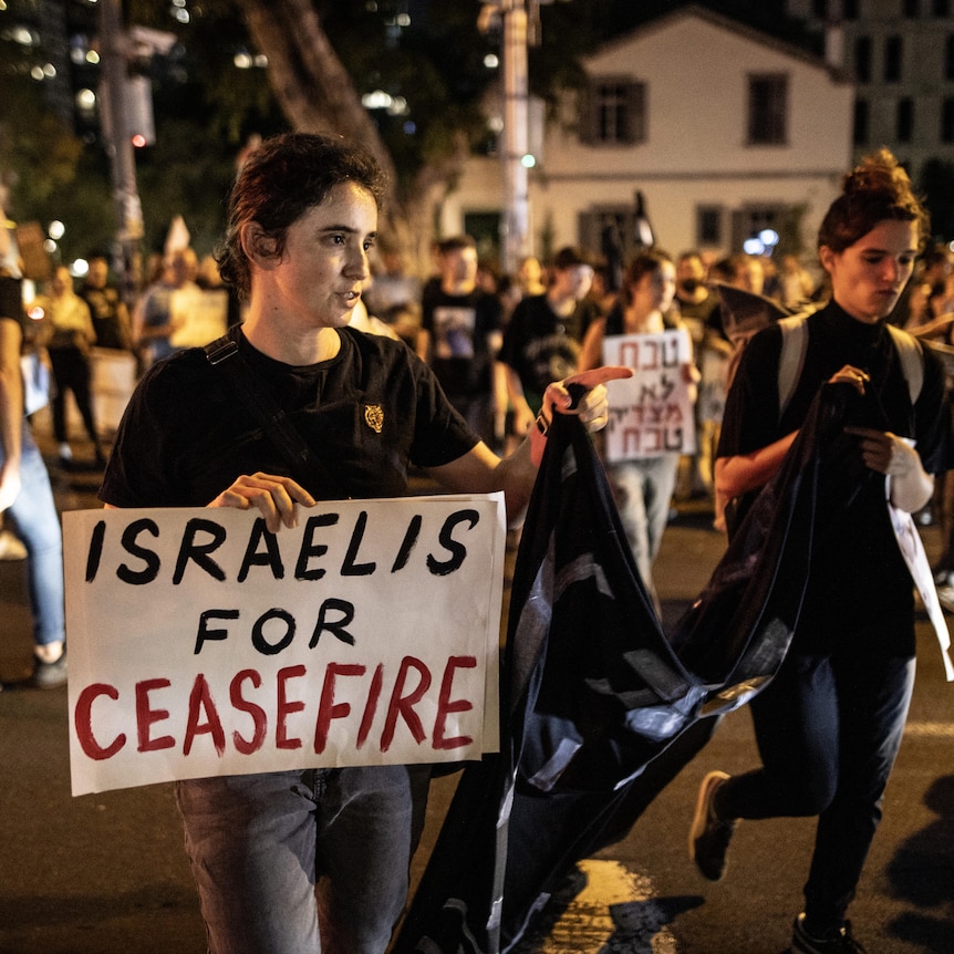 Young people in Tel Aviv with sign demanding ceasefire