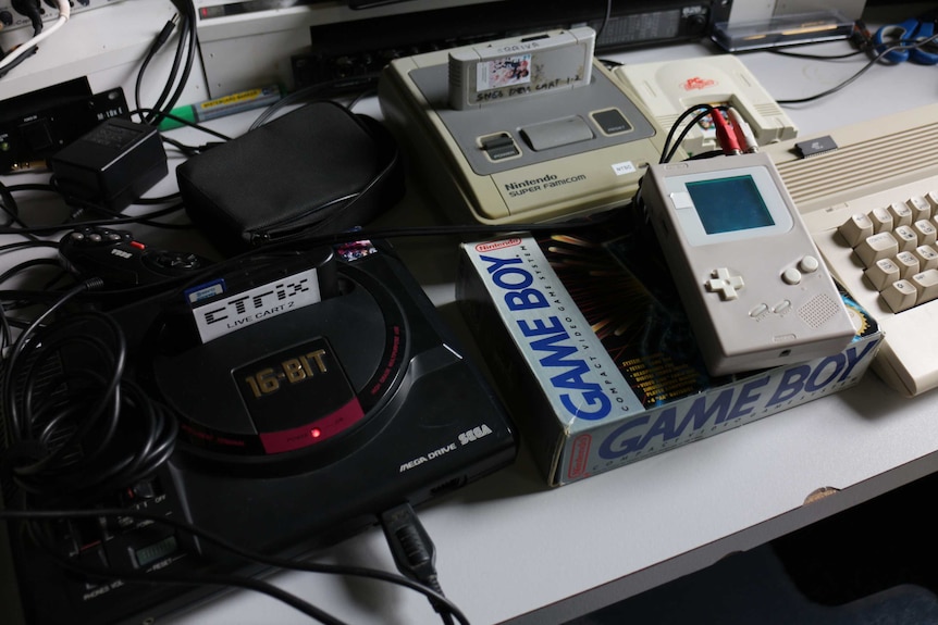 A pile of old Nintendo, Sega and other game consoles.