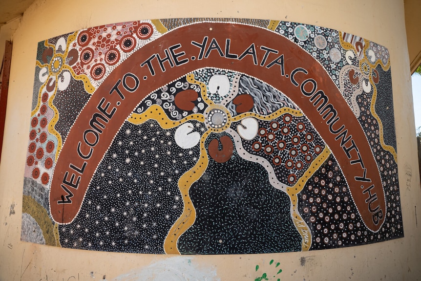 A sign featuring Aboriginal artwork and the words Welcome to the Yalata Community Hub 