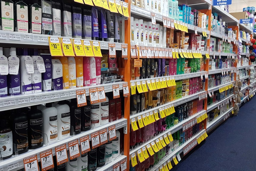 Six shelves of shampoo and conditioners in a chemist shop