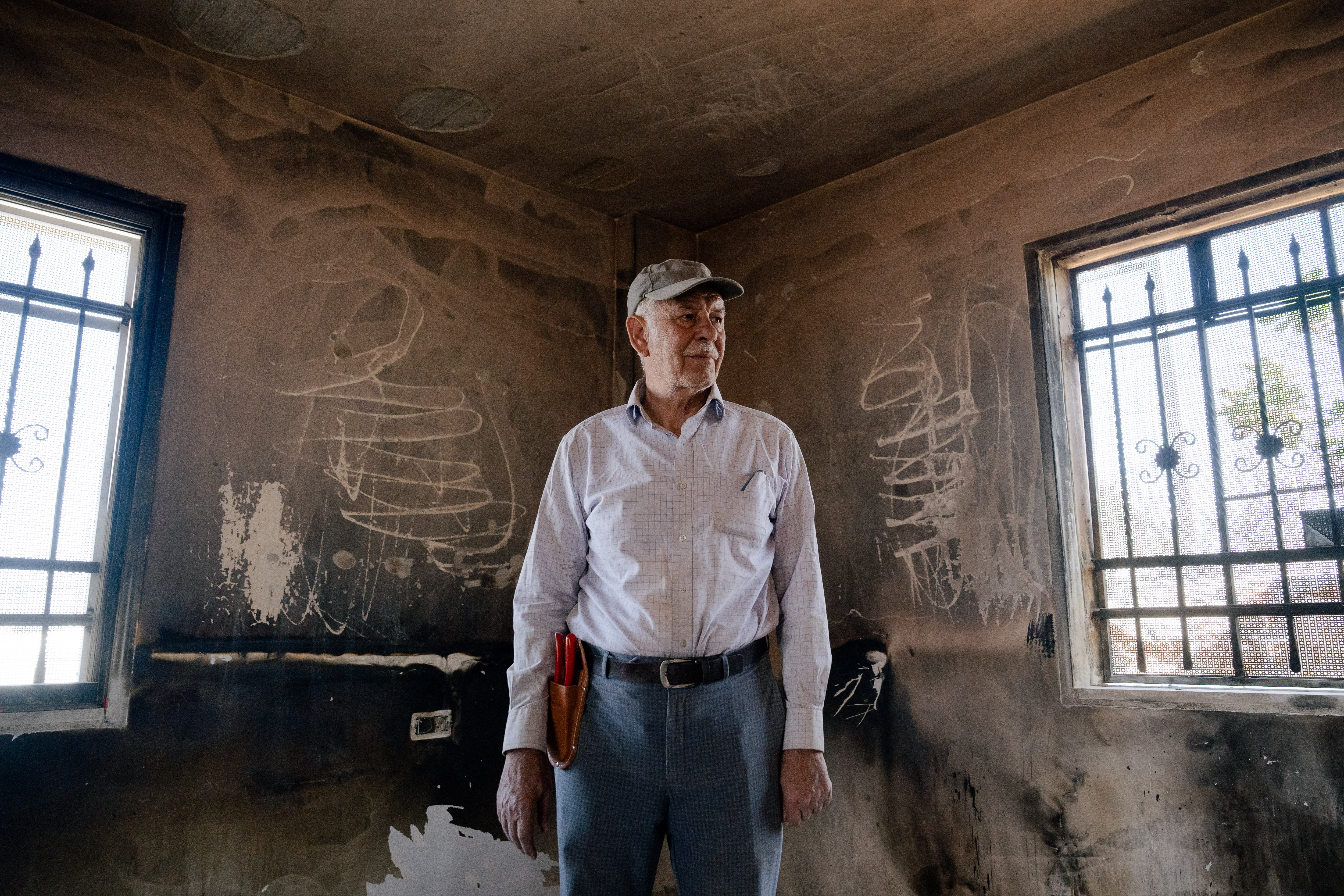 A man standing in a room with charred walls