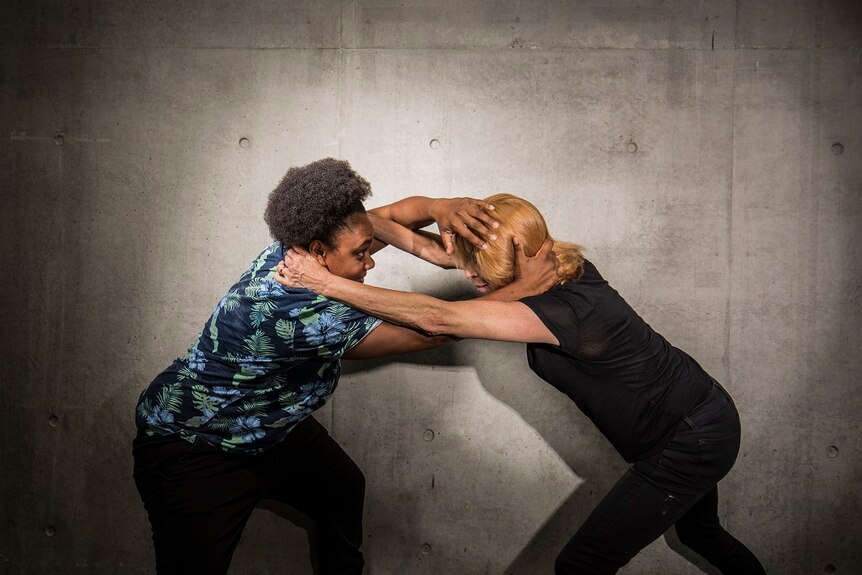 Dancer Ghenoa Gela and actress Heather Mitchell pretending to wrestle with each other.