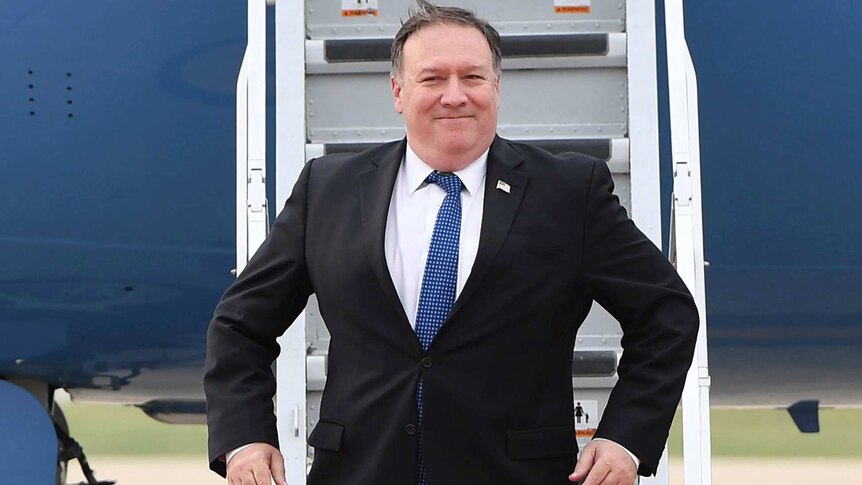 Mike Pompeo exits his plane with a smile