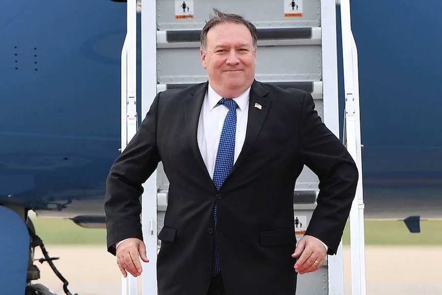Mike Pompeo exits his plane with a smile