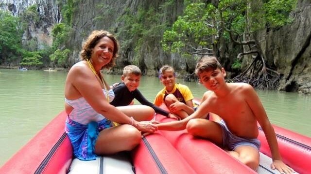 Susan Sullivan (left), Tommy Boyd, Jackson Boyd and Daniel Boyd in a boat on the water in Thailand.