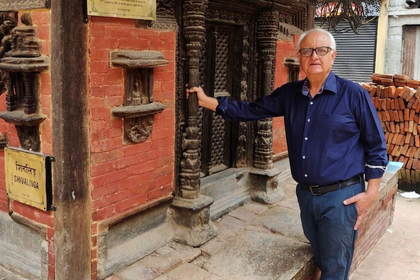 Man Kanak Mani Dixit smiles at ancient carvings in Patan.