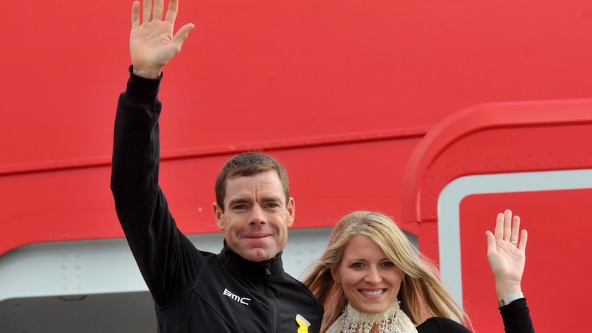 Cadel Evans and wife Chiara wave from the steps of the Qantas plane they arrived on