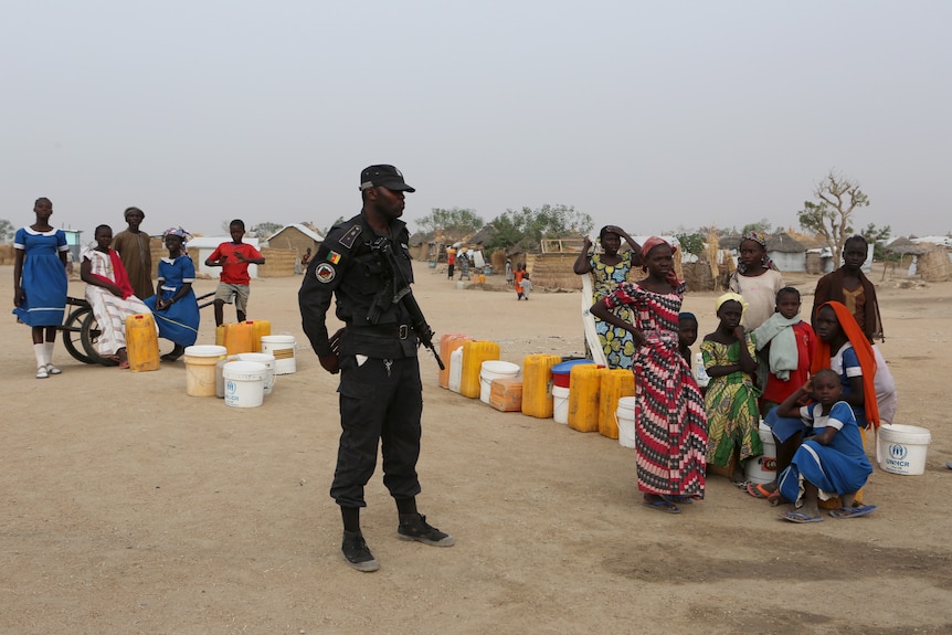 Police officer watches on at refugee camp in Cameroon