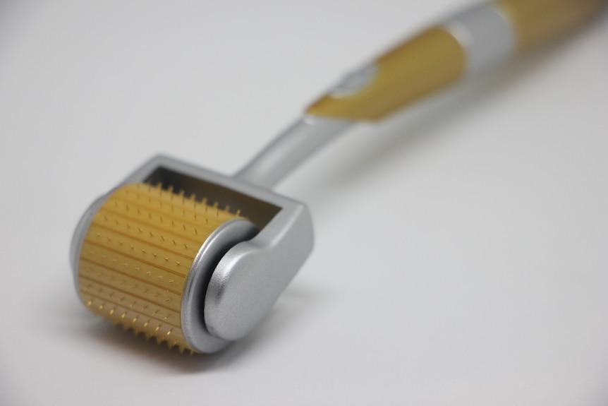 A small round roller with tiny needles used for microneedling.
