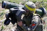 A soldier holds a Javelin missile system during a military exercise.