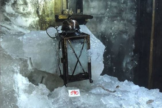 An antique lamp is seen partly encased in ice