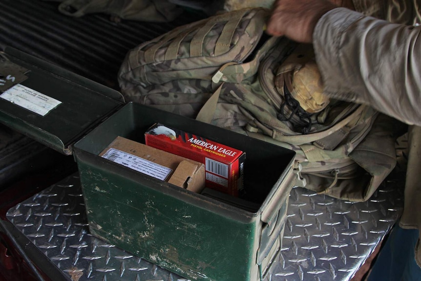 A photo of a cannister of bullets sitting on the tray of a ute.