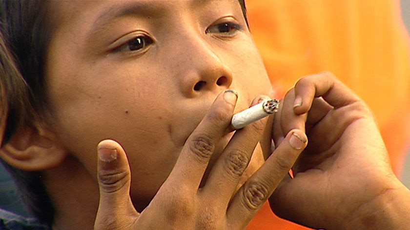 A child smokes a cigarette in Indonesia.