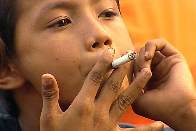 A child smokes a cigarette in Indonesia.