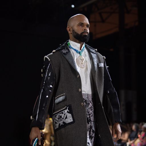 A man wearing a white shirt and silver encrusted black jacket 