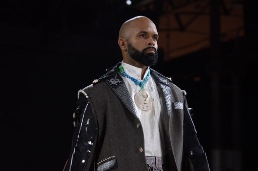 A man wearing a white shirt and silver encrusted black jacket 