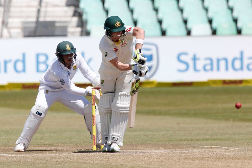 South Africa's Quinton de Kock looks on as Australia's Steve Smith plays a shot.