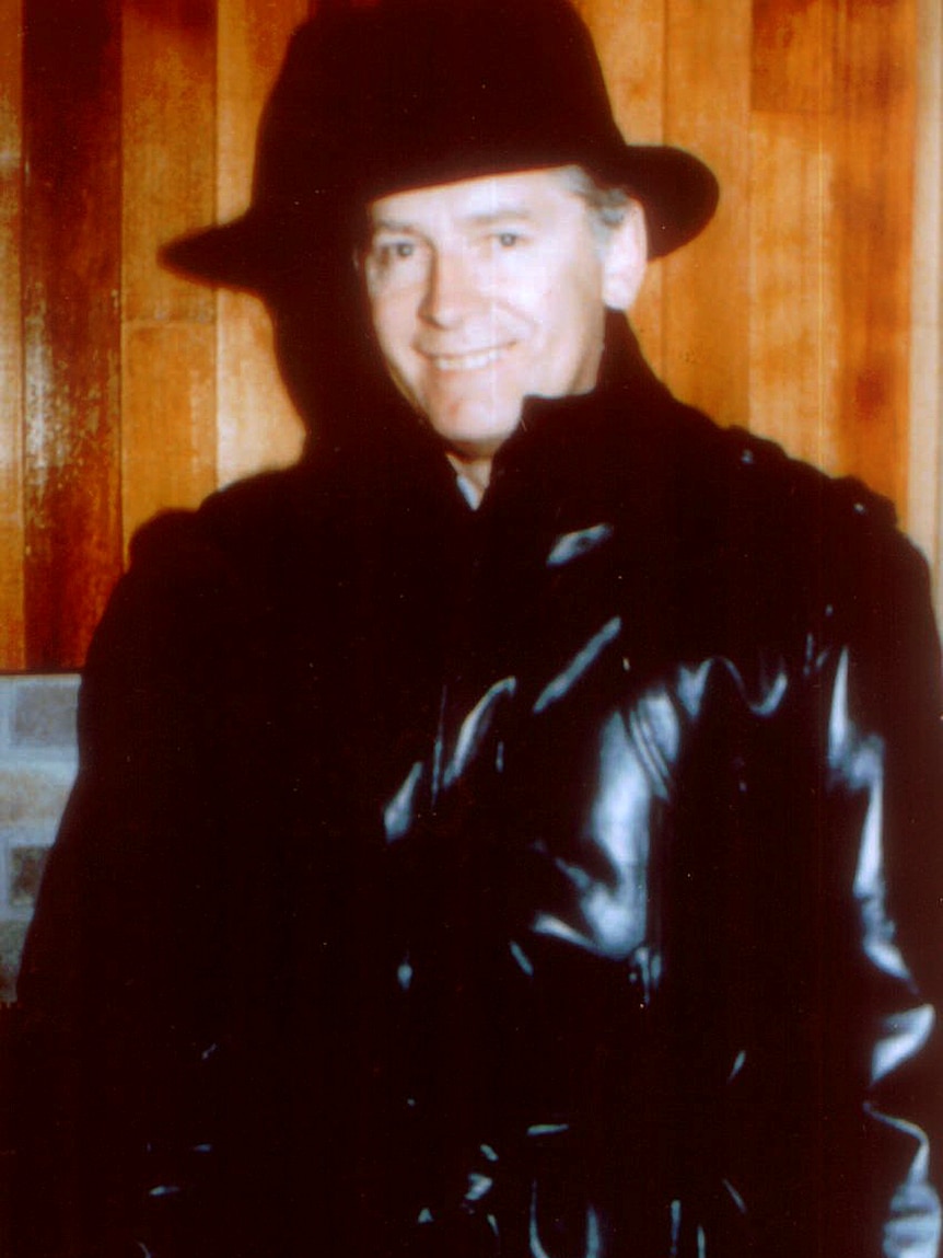 James 'Whitey' Bulger with hat and leather trench coat, smiles in an undated photo.