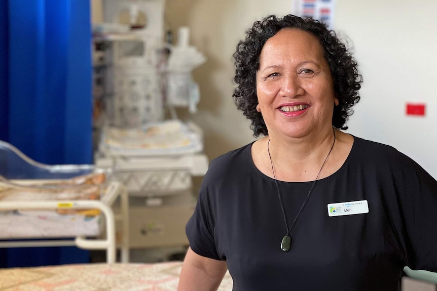 A midwife poses for a photo in a birthing suit of a hospital