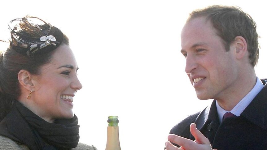 Prince William applauds his fiancee, Kate Middleton, after she poured champagne over a lifeboat