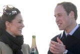 Prince William applauds his fiancee, Kate Middleton, after she poured champagne over a lifeboat