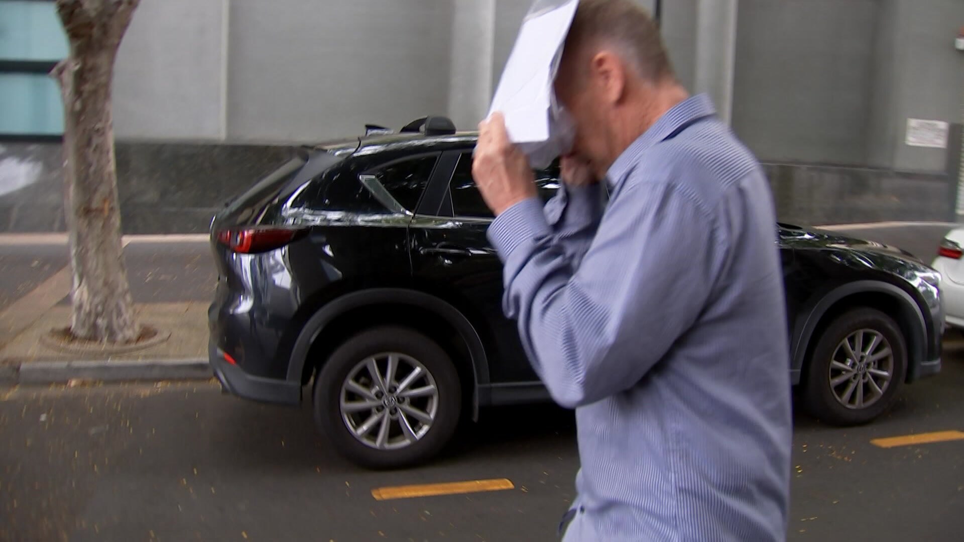Christopher Martin Bulbrook holds a piece of paper in front of his face