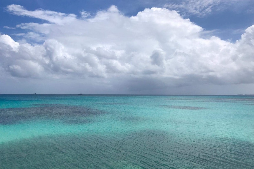 Blue sky with clouds and turquoise waters.