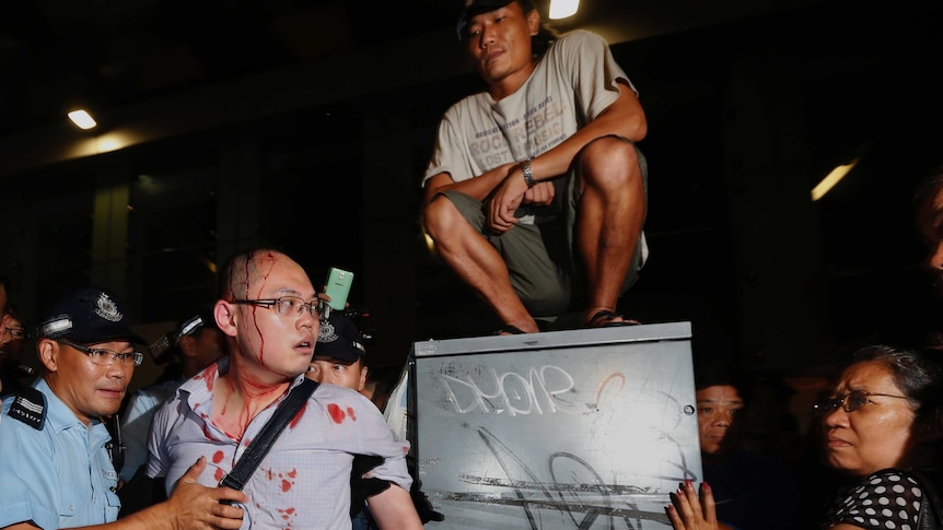 Police assist a bloodied pro-democracy protestor in Hong Kong