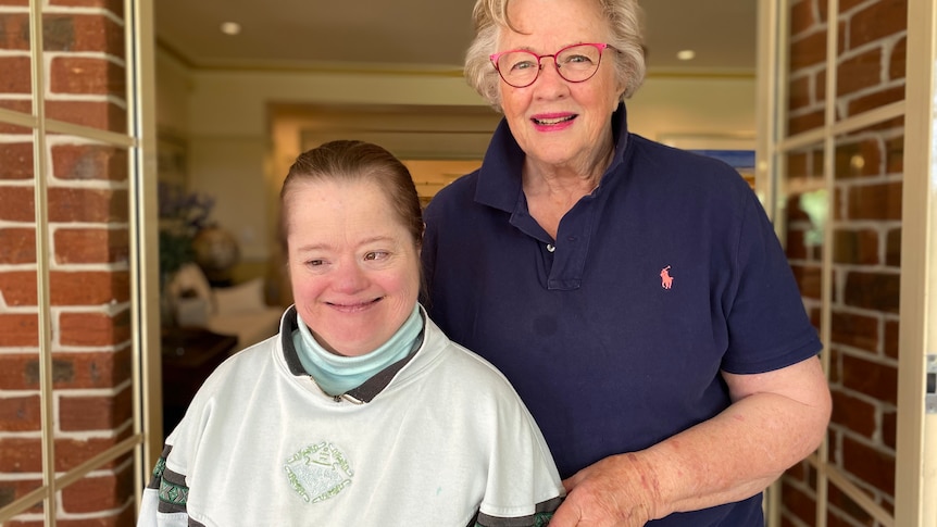 A woman and her daughter smiling at the camera