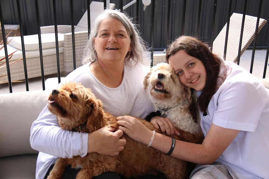 A woman with grey hair smiles with a girl with brown hair 