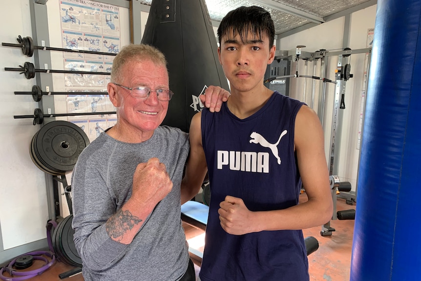 Two men standing in a boxing ring.