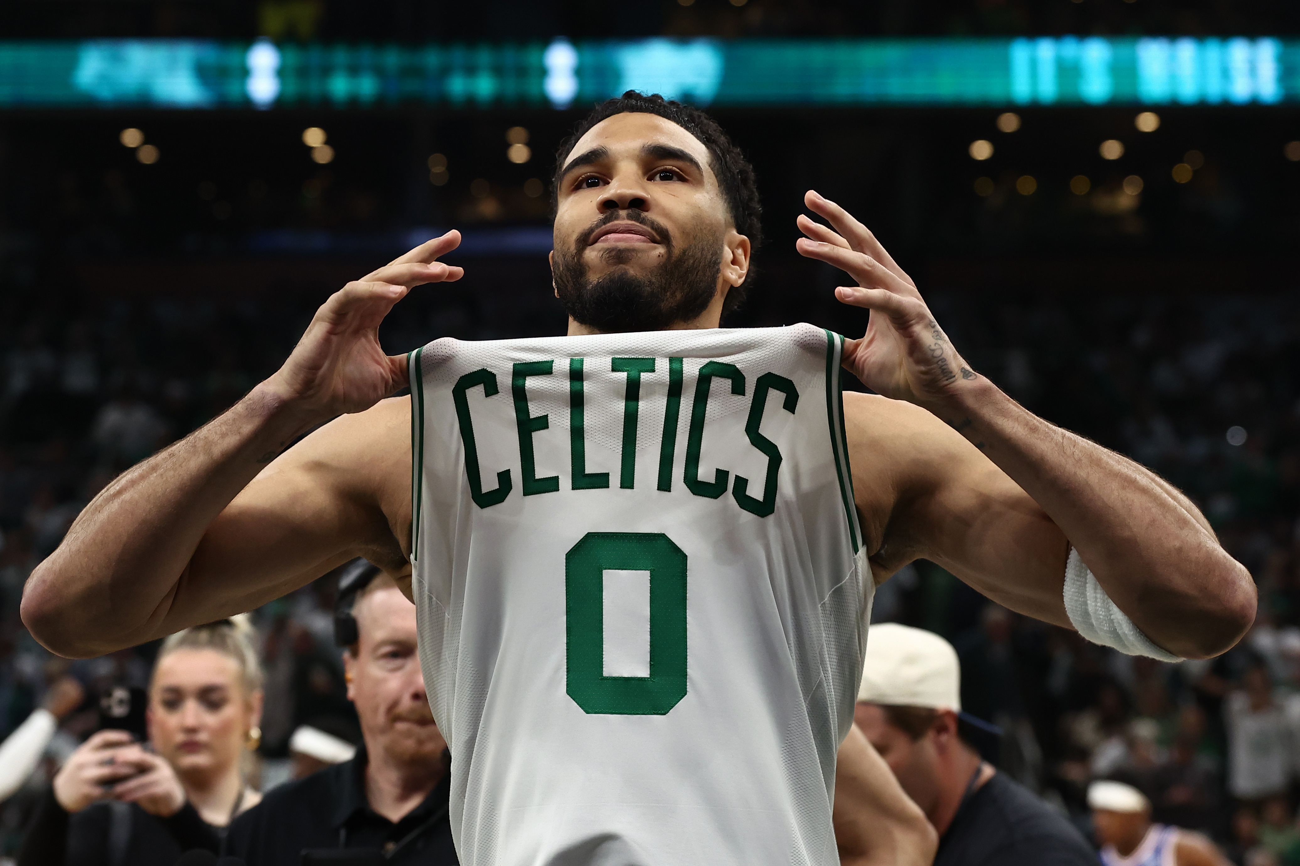 Jayson Tatum holds up his Boston Celtics jersey