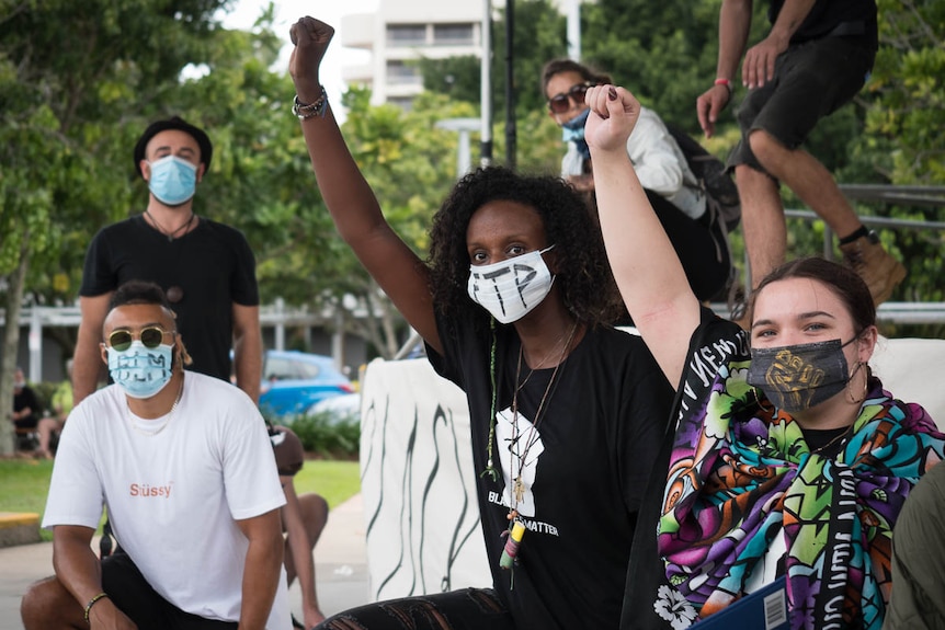 Group of people give Black Panther salute.