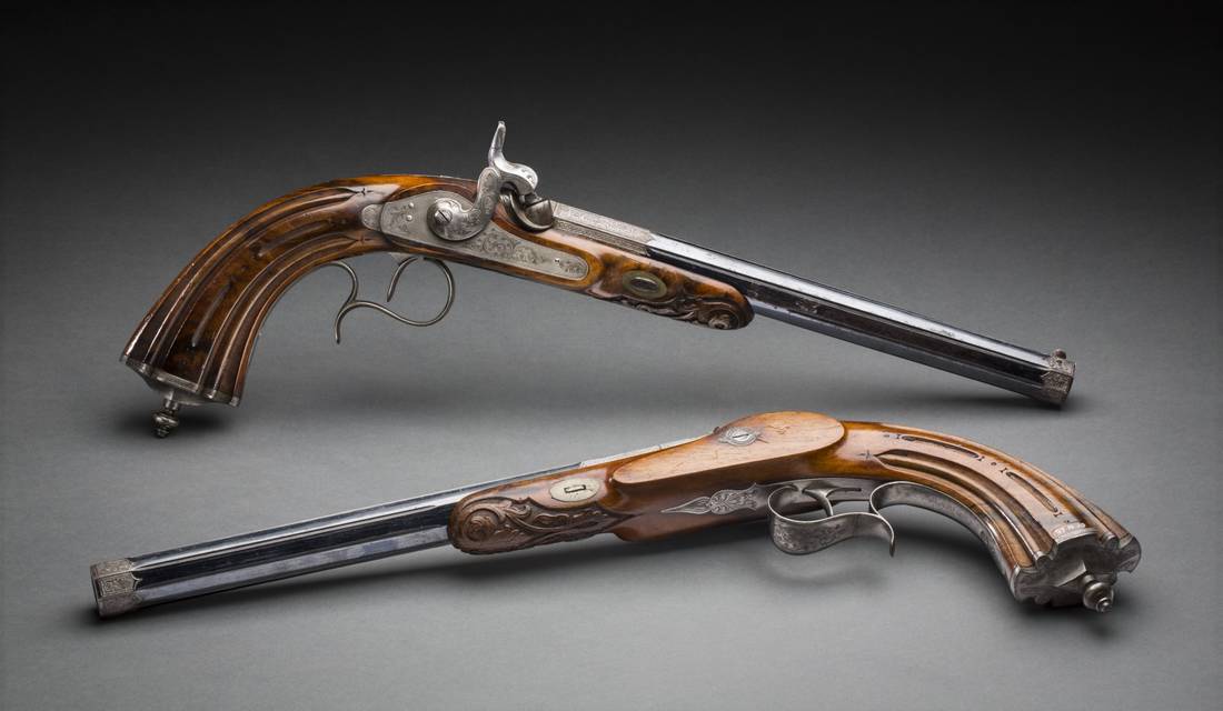 Two pistols with walnut butts.