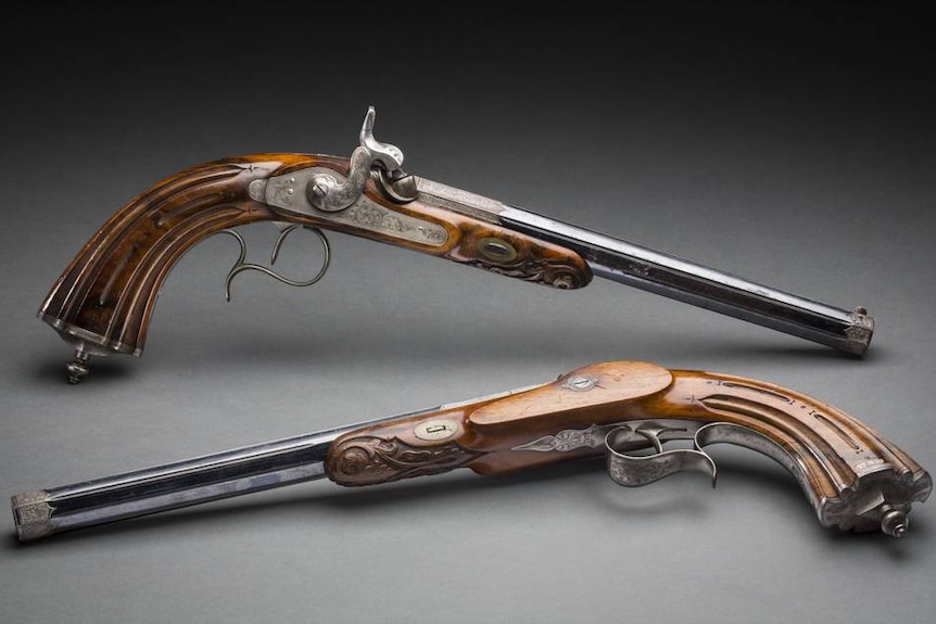 Two pistols with walnut butts.