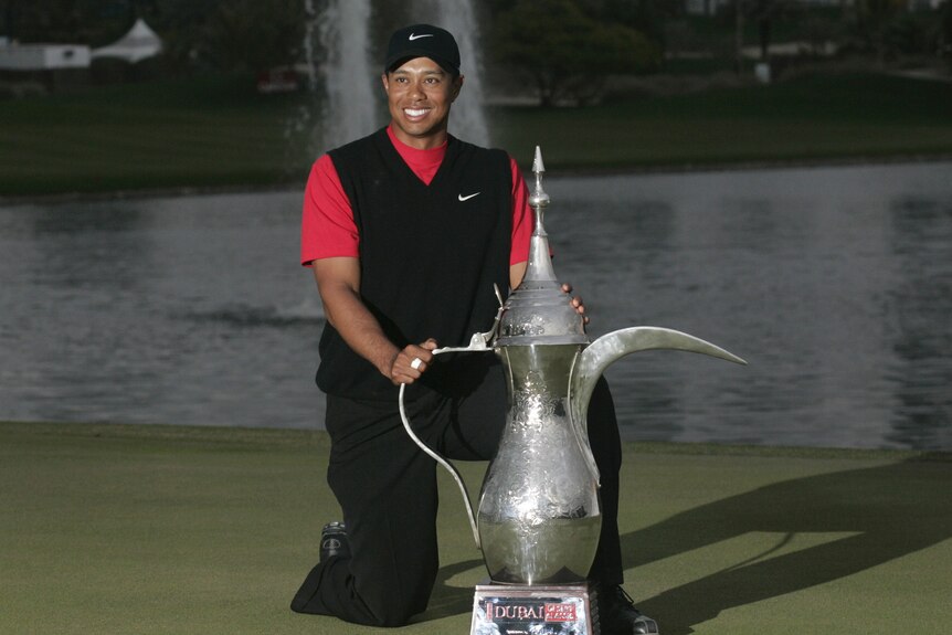 Tiger Woods poses with Dubai Desert Classic trophy