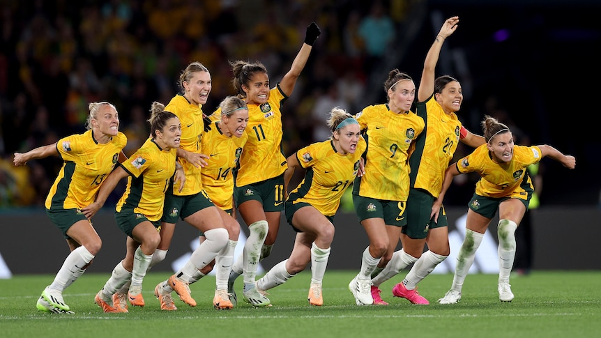 Matildas players celebrate winning penalty against France.