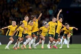 Matildas players celebrate winning penalty against France.