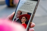 A hand holding a smartphone showing an article about Princess Catherine's cancer diagnosis. 