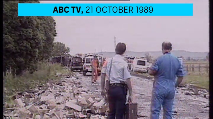 A road accident crash site with two investigators standing on the road.