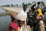 People from a flooded village are rescued by volunteers.