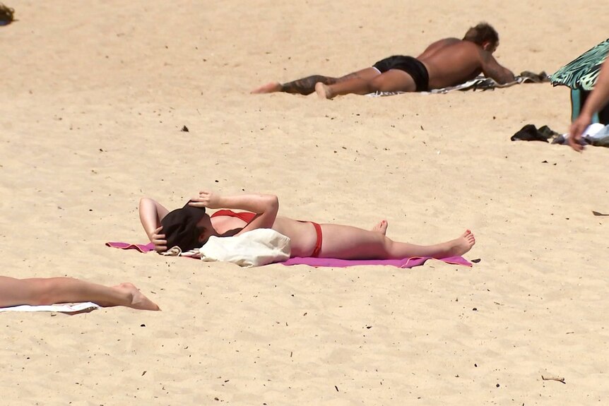 a woman sun baking on the sand