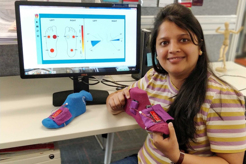 Deepti Aggarwal sitting at a computer which shows the output from sensors on her smart socks