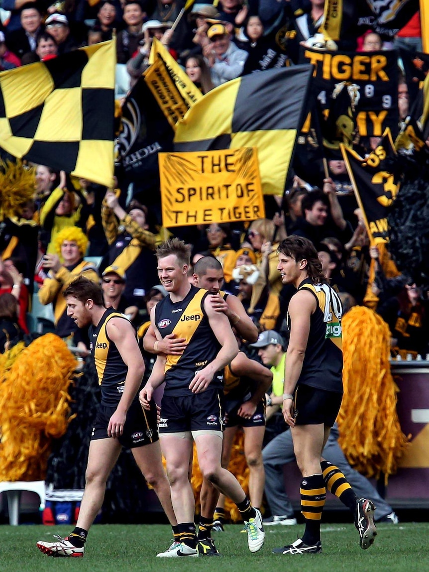 Richmond players rush to congratulate Jack Riewoldt after he kicked a goal.