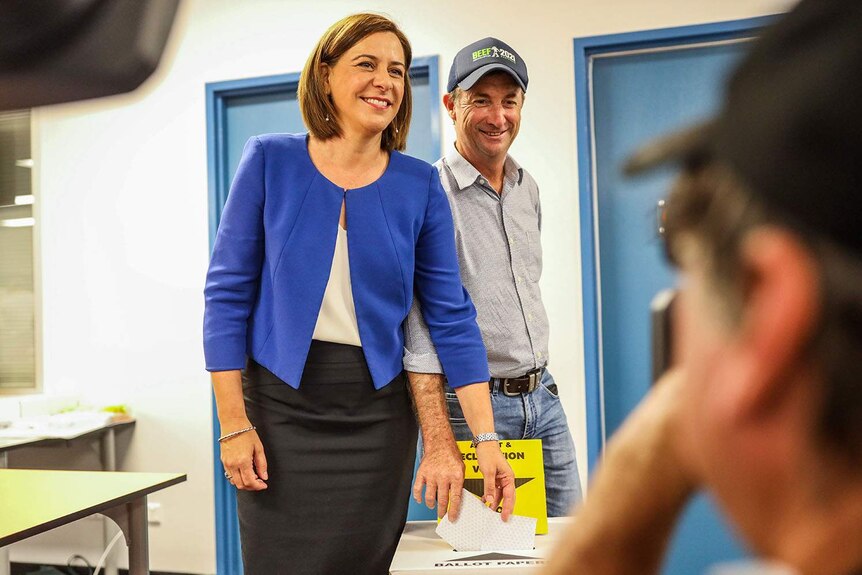 Deb Frecklington smiles as she casts her ballot in the 2020 Queensland election with her husband Jason beside her.