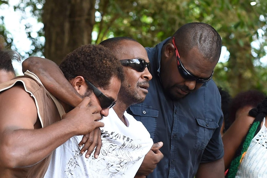 Gavin Willie (centre), the father of four of the eight children near the Manoora house.