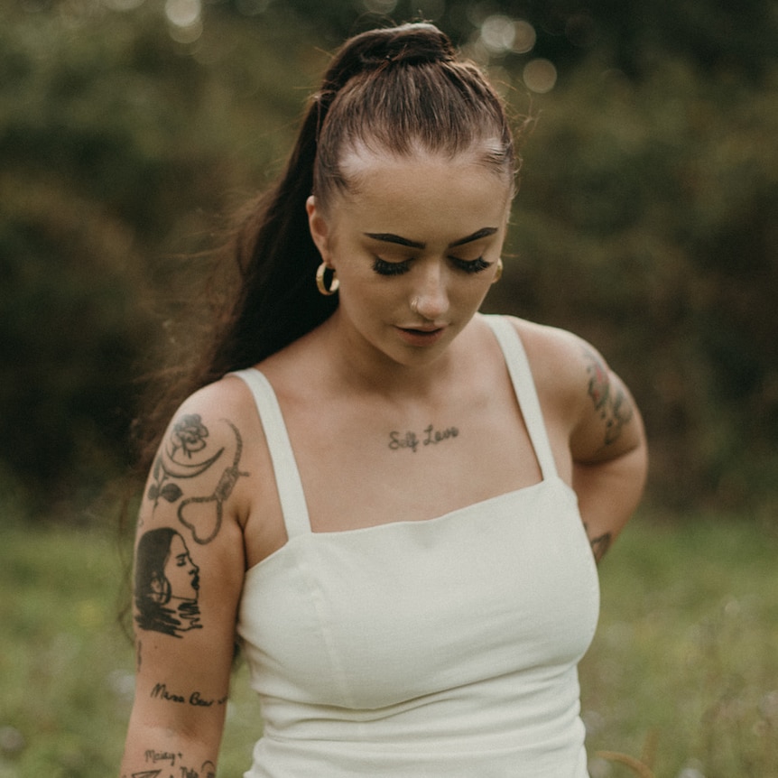 Jessica in a white dress in a field.